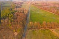 Asphalt road running through meadows and forests.