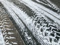 Asphalt with snowy tires imprints. winter background