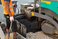 An asphalt spreader or an asphalt paver machine on a road construction site. Road repairs.