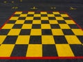 painted yellow and black chess board on asphalt surface