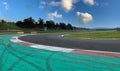 Asphalt turn track on motorsport circuit with large green trap area and brakes skid marks