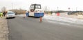 Asphalt works on the city road with machinery and workers.