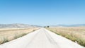 Asphalted road in a deserted field, the road goes to the horizon