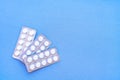 Aspirin in a blister on top. Vitamin C pills in a pack. White tablets in a blister on a blue background close-up with soft focus. Royalty Free Stock Photo