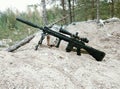 Assault rifle on the background of pine forests and sand Royalty Free Stock Photo