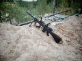Assault rifle on the background of pine forests and sand Royalty Free Stock Photo