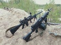 Assault rifle and machine gun on the background of pine forests and sand Royalty Free Stock Photo