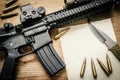 Assault rifle, paper and bullets on the table Royalty Free Stock Photo