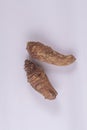 Assava tubers fresh on isolated white, pile cassava manioc in top view, yucca root for flour products, raw materials for tapioca