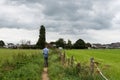 Asse, Flemish Brabant - Belgium - Man walking a soft trail between green agriculture fields