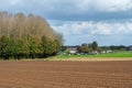 Asse, Flemish Brabant, Belgium - Plowed land, trees and a parking lot at the Flemish countryside