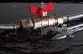 Assembled flexible fittings, ball valve, union and adjustable wrench in water with falling drops and waves Royalty Free Stock Photo