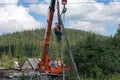 Assembling climbed a pole and tie him with chains to the crane boom for further disassembly.