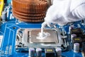 Assembling a computer in white gloves, applying thermal paste to the processor Royalty Free Stock Photo
