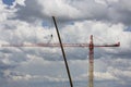 Assembling of crane on dramatic cloudy background. Dangerous height situation. Royalty Free Stock Photo