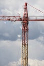 Assembling of crane on dramatic cloudy background. Dangerous height situation.