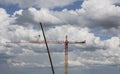 Assembling of crane on dramatic cloudy background. Height tower crane.