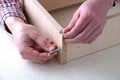 Assembling a furniture box, male hand holding a screw and tightening it