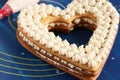 Assembling a heart-shaped cake using butter cream