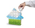 Assembling house shape puzzles in beautiful landscape Royalty Free Stock Photo