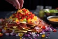 assembling nacho layers with toppings in close-up