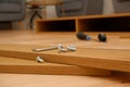 Assembly of furniture, the different parts and pieces of furniture arranged on the wooden floor. DIY furniture assembly concept Royalty Free Stock Photo