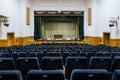 Assembly hall with stage for performance and rows of empty dark blue seats Royalty Free Stock Photo