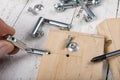 Assembly of the hinge used in the construction of furniture. Minor carpentry work performed in the workshop Royalty Free Stock Photo