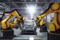 Assembly line in a modern car factory with robots and workers assembling vehicles, conveyor belts moving car parts