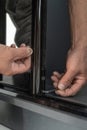 Assembly of mirrored doors to a sliding wardrobe, installation of a case by means of the hexagonal screw. Royalty Free Stock Photo