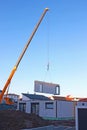 Assembly of a prefabricated house, crane lifting a wall component Royalty Free Stock Photo