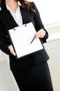 Assertive businesswoman taking notes on clipboard