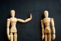 Assertiveness and confidence concept. Two wooden figurines on the dark surface. Royalty Free Stock Photo