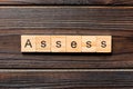 ASSESS word written on wood block. ASSESS text on wooden table for your desing, concept