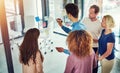 Assessing their success over time. a group of young designers brainstorming with notes on a glass wall in an office.