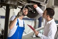 Assessor And Repair Man Examine Car