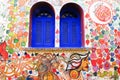 Blue windows and Colorful graffiti wall colourful leaves  in Asilah, Morocco. Royalty Free Stock Photo