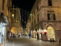 ASSISI, ITALY - DECEMBER 18, 2023: Historic street of Assisi during christmas time at night