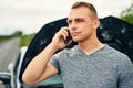 Assistance is on its way. Shot of a young man calling roadside assistance after breaking down. Royalty Free Stock Photo