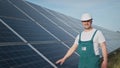 Assistance technical worker in uniform is checking an operation and efficiency performance of photovoltaic solar panels Royalty Free Stock Photo