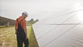 Assistance technical worker in uniform is checking an operation and efficiency performance of photovoltaic solar panels Royalty Free Stock Photo