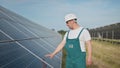 Assistance technical worker in uniform is checking an operation and efficiency performance of photovoltaic solar panels Royalty Free Stock Photo