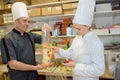 Assistant and chef discussing menu in kitchen Royalty Free Stock Photo