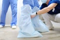 The assistant helps the surgeon to put on a medical shoes covers. Doctor is preparing for surgery in operation room Royalty Free Stock Photo