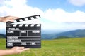 Assistant holding clapperboard outdoors. Cinema production