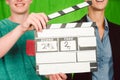 Assistant holds movie slate into the camera to start the product