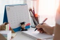 Assistant taking notes. Businessman using pen and takes notes to remind an event in a notebook on office table. Royalty Free Stock Photo