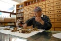 Chinese herbalist weighs herbs for customer in Chinatown, Oakland, CA