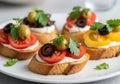 Assorted appetizers featuring olives, tomatoes, and various spreads on toasted bread Royalty Free Stock Photo