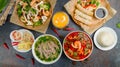 Pho bo, pho tom, noodles, spring rolls, tom yam, rice, mango shake on beautiful black stone table top view Royalty Free Stock Photo